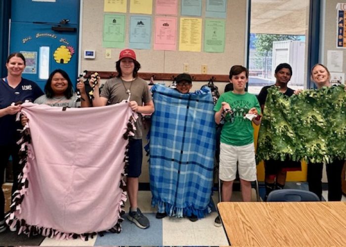 students with DIY blankets they made for animal shelter