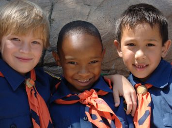 Three boys of diverse ethnic background in cub scout uniforms